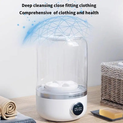 White appliance with digital display on a wooden surface, surrounded by towels and soap.